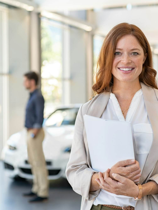 satisfied-saleswoman-in-car-dealership.jpg